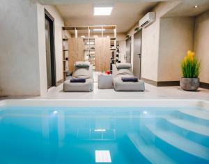 a living room with a swimming pool and two beds at Sandom in Parikia