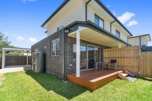 een huis met een houten terras in de tuin bij Rosewater Townhouses Dromana in Dromana