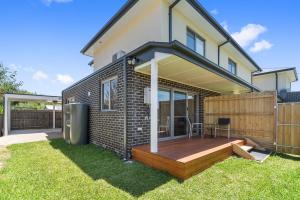 a house with a wooden deck in the yard at Rosewater Townhouses Dromana in Dromana