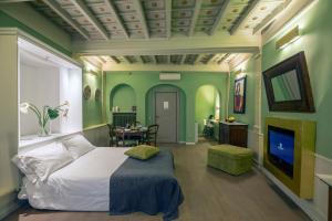 a bedroom with green walls and a bed and a television at Raffaello Charmsuite in Rome