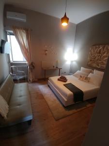 a bedroom with a large bed and a couch at Diadumeno Great Apartment in Venosa