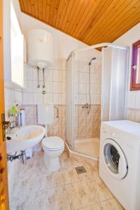 een badkamer met een wastafel en een wasmachine bij Apartment Šare in Betina
