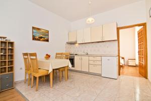 een keuken en eetkamer met een tafel en stoelen bij Apartment Šare in Betina