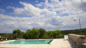 een zwembad aan de zijkant van een villa bij Masseria Guadiano Vecchio in Santa Lucia