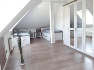 Habitación en el ático con cama y jarrón de flores en Ferienwohnung Osterheide en Schneverdingen