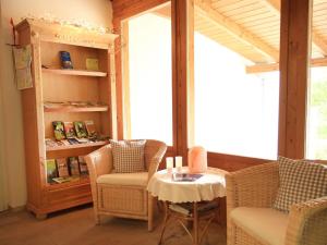 a room with chairs and a table and a book shelf at Pension Arzberghof in Beilngries