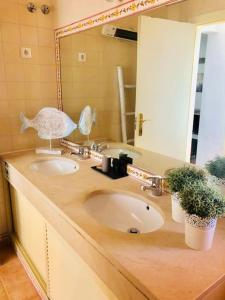 a bathroom with two sinks and a large mirror at Sea Breeze Golf & Beach Villa in Charneca