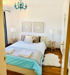 a bedroom with a bed with two towels on it at Sea Breeze Golf & Beach Villa in Charneca +26 photos