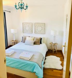 a bedroom with a bed with two towels on it at Sea Breeze Golf & Beach Villa in Charneca