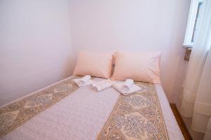 a bed with two pillows and two towels on it at Loredana 1 in Veli Lošinj