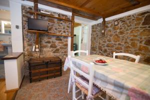 a dining room with a table and a stone wall at Loredana 1 in Veli Lošinj