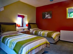 two beds in a room with red walls at Bryn Melyn Apartments in Barmouth