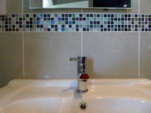 a bathroom sink with a faucet on top of it at Bryn Melyn Apartments in Barmouth
