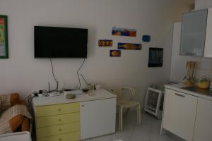 a kitchen with a tv on a wall with a dresser at Casa Del Mulino in San Vito lo Capo