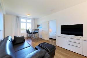 Il comprend un salon doté d'un canapé et d'une télévision à écran plat. dans l'établissement Apartment Traveblick, à Lübeck