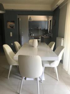 - une table à manger blanche et des chaises dans la cuisine dans l'établissement Athens-Glyfada apartment, à Athènes