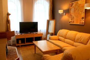 a living room with a couch and a tv at Gustav House in Daugavpils