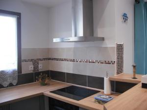 une cuisine avec un évier et une cuisinière dans l'établissement Appartement Palm'Ares, à Arès