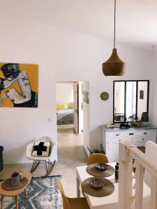 a living room with white walls and a table and chairs at Nuits étoilées Lourmarin in Lourmarin