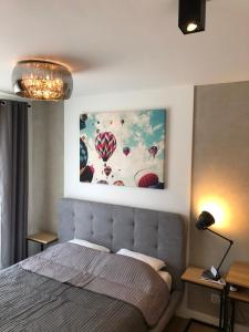 a bedroom with a bed and a painting of balloons at Like at Home Warsaw in Warsaw