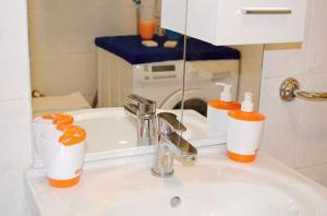 a bathroom sink with toothbrushes and bottles on it at Apartment Sunset in Trogir +87 photos