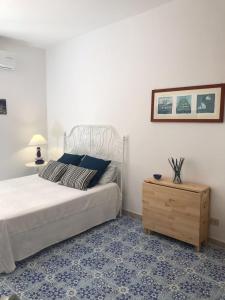 um quarto com uma cama e uma mesa de cabeceira em madeira em Vic e Vicariell em Gaeta