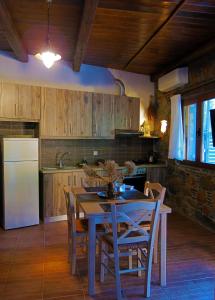 cocina con mesa, sillas y nevera en "PefkoPetro" Traditional House, en Keramotí