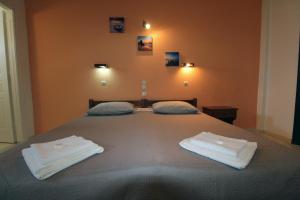a hotel room with a bed, desk, and nightstand at Stars Hotel in Agios Georgios