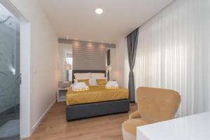 a bedroom with a bed and a chair at Gallery Rooms with Parking in Zadar