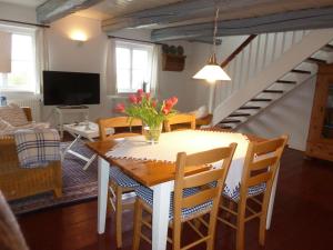 a dining room and living room with a table and chairs at Hof Homfeld in Ditzum