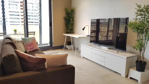 salon z kanapą i telewizorem z płaskim ekranem w obiekcie 2BEDS Melbourne Central|Crown Casino|Colin|S Cross w Melbourne