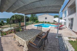a patio with a table and chairs and a pool at Apartment Karasi in Pomer