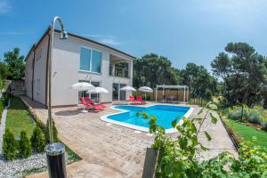 a villa with a swimming pool and a house at Apartment Karasi in Pomer