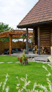 a log cabin with a deck and a pavilion at Guest house Zvejnieksēta in Pāvilosta