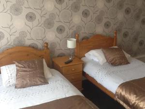a bedroom with two beds and a lamp on a night stand at George & Dragon in Coleshill +15 photos