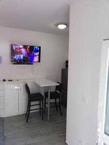 a room with a table and chairs and a tv on the wall at Apartment Vinko in Split
