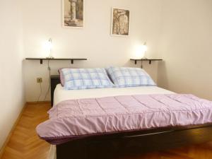 1 cama en una habitación con 2 lámparas en la pared en Apartments Spada, en Poreč