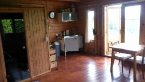 a room with a table and a kitchen with wooden walls at Koningsheim in Colijnsplaat