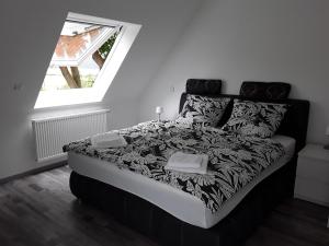 czarno-białe łóżko w pokoju z oknem w obiekcie Ferienwohnung Aufderhaar w mieście Ostbevern