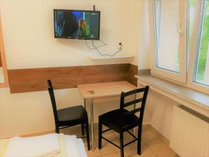 a small table with two chairs and a tv on a wall at Hotel Moji Köln in Cologne