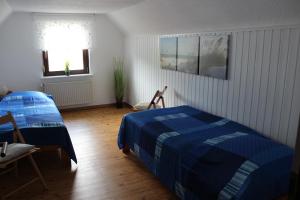 a bedroom with a bed and a table and a window at Casa Metzjersch in Gemünden