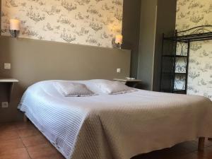 a bedroom with a bed with a white blanket at La Rapière in Carcassonne