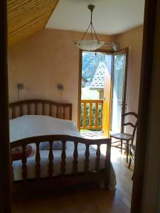 a bedroom with a bed and a large window at Chambre d'hôtes - La Maurillonnette in Saint-Pancrace