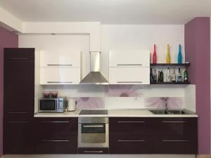 a kitchen with white cabinets and a stove top oven at Fantasy Beach Apartment in Golem