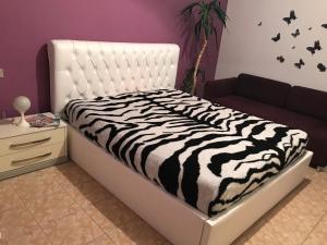 a zebra print bed in a room with a couch at Fantasy Beach Apartment in Golem