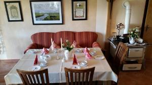 a table with a white table cloth and red napkins at Café Hausnordlicht - Ferienwohnung 2 in Dornum