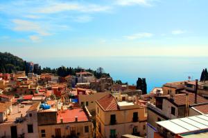 a view of a city with buildings and the ocean at Residence Circe in Taormina