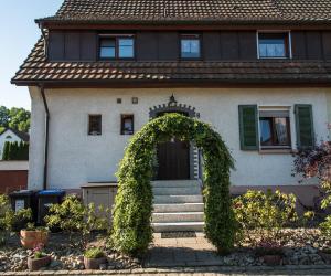 a house with an arch in front of it at Ferienwohnung "Hirsch Hüsli" in Schopfheim
