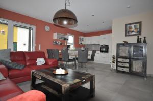 a living room with a red couch and a table at Ferienhaus Seerose in Hohenfelden