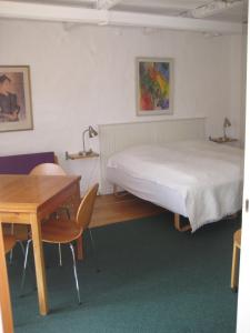 - une chambre avec un lit, un bureau et une table dans l'établissement Farmer Annekset Ravning, à Bredsten